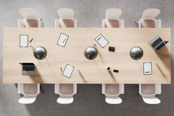 istock A modern office meeting table from top view with laptops, clipboards, and chairs on a concrete background, concept of teamwork. 3D Rendering 2154704007