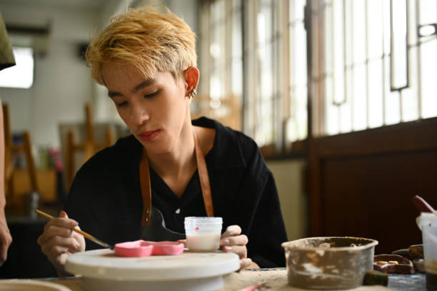 istock Focused LGBT teenage student working on a clay piece during art class, representing dedication and skill 2154704423