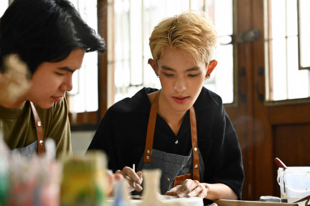 istock A teacher and student engage in a pottery lesson, focused on shaping clay together. The educational and artistic process in a creative studio environment, highlighting learning and mentorship in art 2154705024