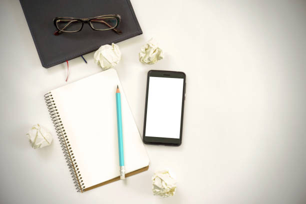 notebook with phone, glasses and pencil on a white ground. design concept. copy space