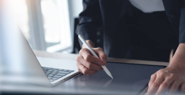 istock Businesswoman using stylus pen signing on digital tablet via mobile app, proofing e-document on office table. Business woman, project manager planning and working on computer, business technology 2154705692