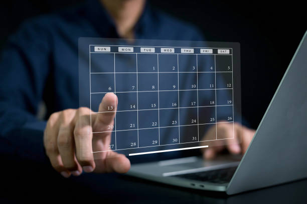 istock Businessman manages time for effective work. Calendar on the virtual screen interface calendar schedule time plan appointment, data management system, checking organizes day, week, month project list, business, calendar appointment plan concept 2154707849