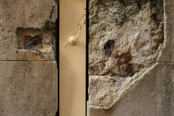 Close-up on a wooden support post in an old damaged concrete wall