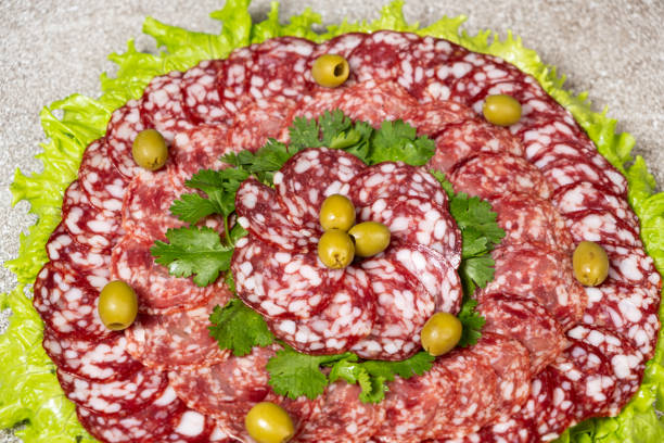 Thinly sliced smoked salami sausage with cilantro and olives.