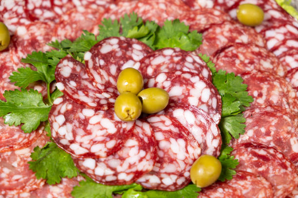 Thinly sliced smoked salami sausage with cilantro and olives.