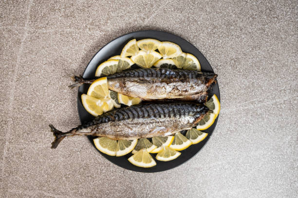 istock Oven-baked mackerel sea fish dish served with fresh lemon slices 2154712384
