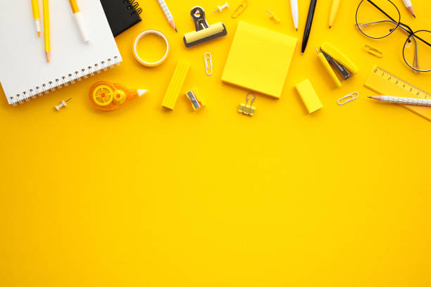 istock Vibrant office supplies on yellow background. Flay lay composition with sticky notes, paper notebook, eyeglasses, pen, pencils and more different stationery. 2154713399