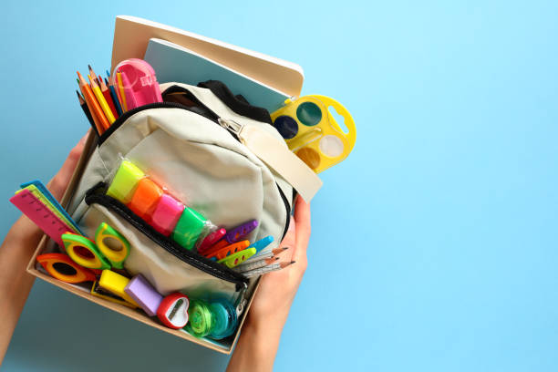 istock Donation box with backpack with school supplies on a blue background. Charity concept. 2154713488