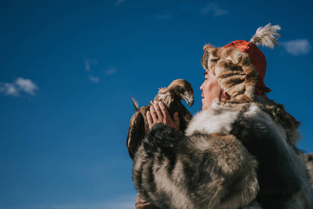 proud Kazakh eagle hunters talking to golden eagle at Bayan Olgii, West Mongolia