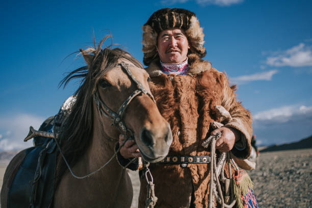 Proud Kazakh eagle hunters and his horse at Bayan Olgii, West Mongolia