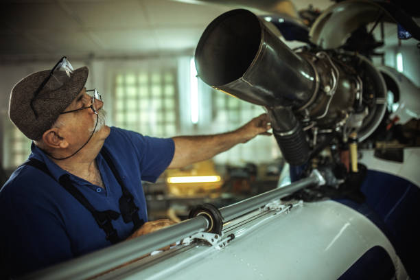Senior mechanic working on helicopter in hangar