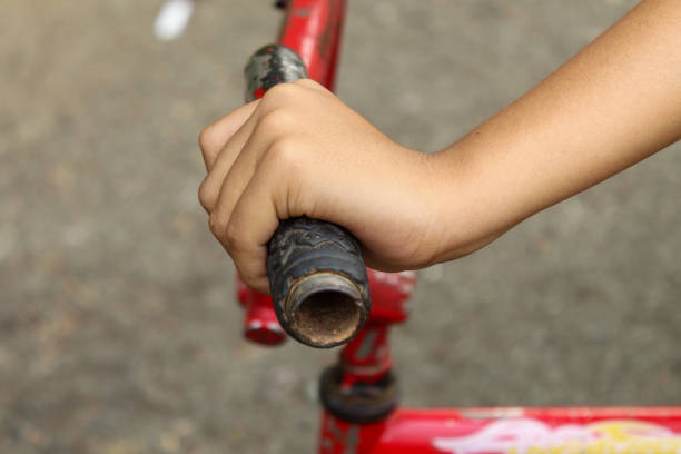 child's hand on bicycle handlebar close up