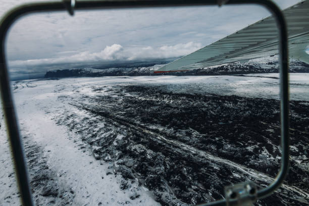 Dramatic aerial view of huge glacier and black volcanic sand surrounded by majestic mountain peaks in Vatnajokull National park, South Iceland