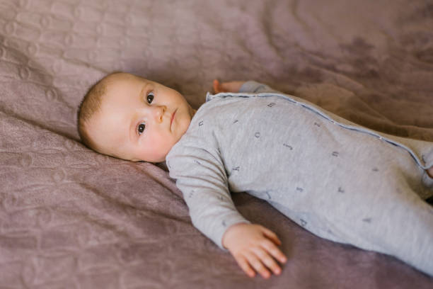 istock Cute baby is lying on his back on the bed 2154719787