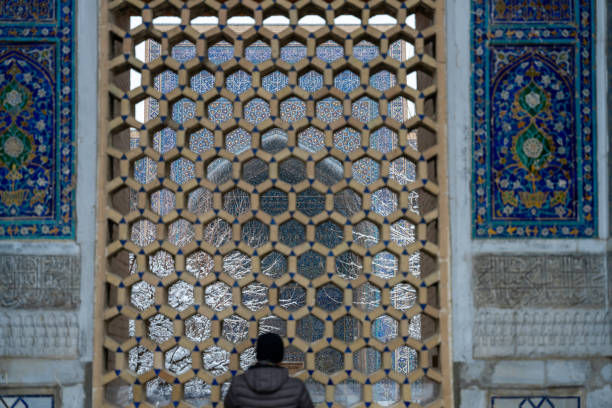 istock A man is looking out of a window with a blue and white design 2154723769