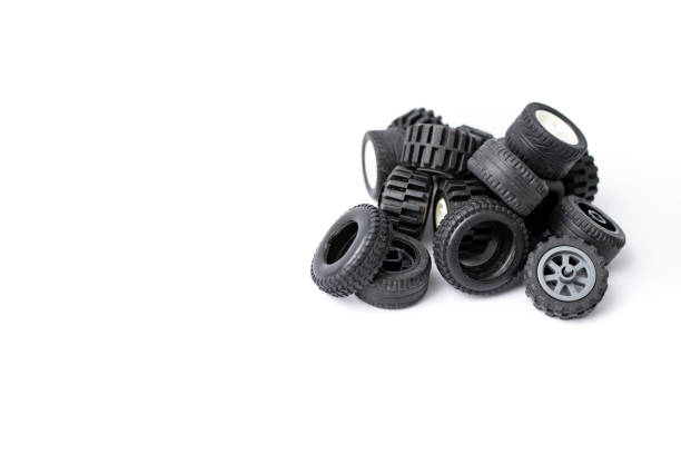 Different patterned wheels and rubber from child toys, stacked and isolated on white