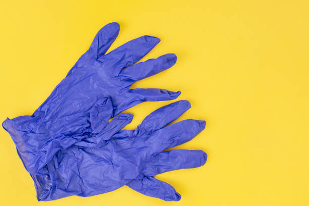 istock Blue latex surgical gloves on yellow background, abstract backdrop 2154724399
