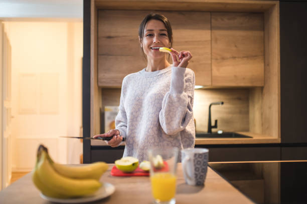 istock Cute young woman cooking breakfast and looking contented 2154725869
