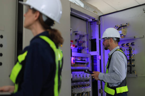 istock Industrial service electrician engineers stand side by side, exchanging ideas in front of the electricity control board. Energy management system (EMS) concept Main Distribution Board 2154732155