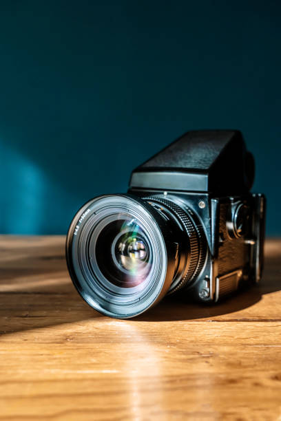 istock Camera is on the table. Medium format analog film camera on a blank background. Retro vintage technology style 2154732214