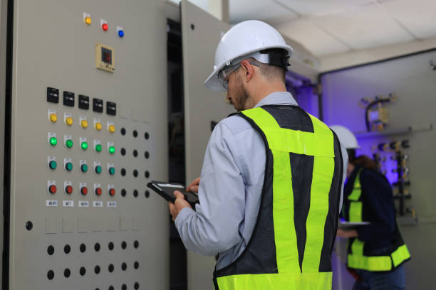 istock Two Caucasian white professional electrician engineers working with a computer and digital tablet in the main electric control room of the factory, MDB Main Distribution Board 2154732252
