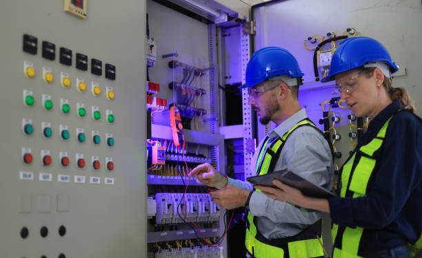 istock Two Caucasian white professional electrician engineers working with a computer and digital tablet in the main electric control room of the factory, MDB Main Distribution Board 2154732261