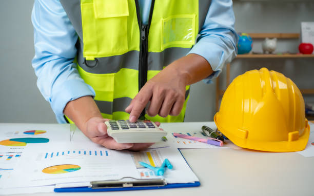 istock A foreman sits at a desk in an office, Calculating costs, Planning construction, Calculating structures, Planning and calculating project construction costs, Project presentation plan. 2154739746