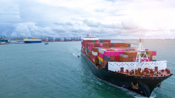 istock Side view of Cargo container ship carrying container and running out international container port customs shipyard sea port concept smart logistic service. 2154740254