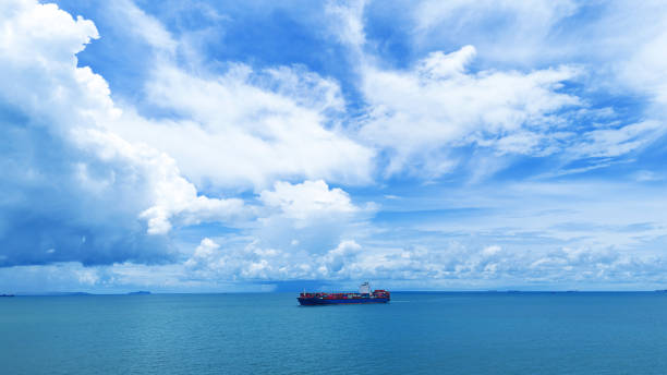 istock Side Cargo container ship on beautiful sky cloud carrying container and running out international container port customs shipyard sea port concept smart logistic 2154740293