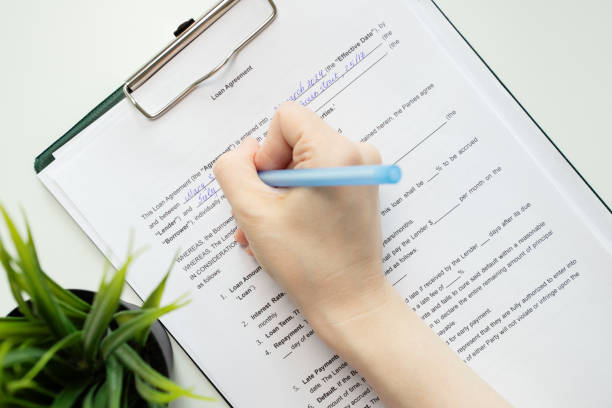 istock Loan agreement, hand fills out a document, client contract, banking paperwork, credit approval 2154741260