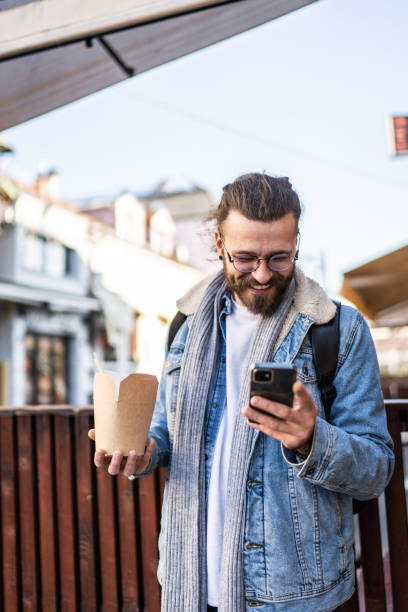 istock Modern young man using cell phone at the city street 2154741461