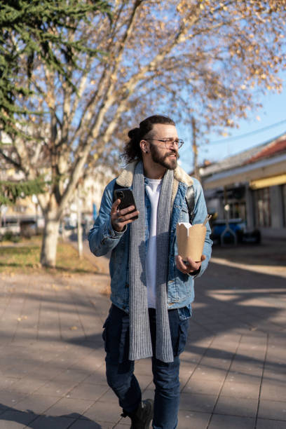 istock Modern young man using cell phone at the city street 2154741547