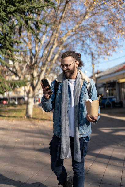 istock Modern young man using cell phone at the city street 2154741569