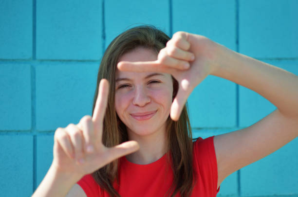 istock A girl is smiling and holding her hands together in a frame. 2154741624