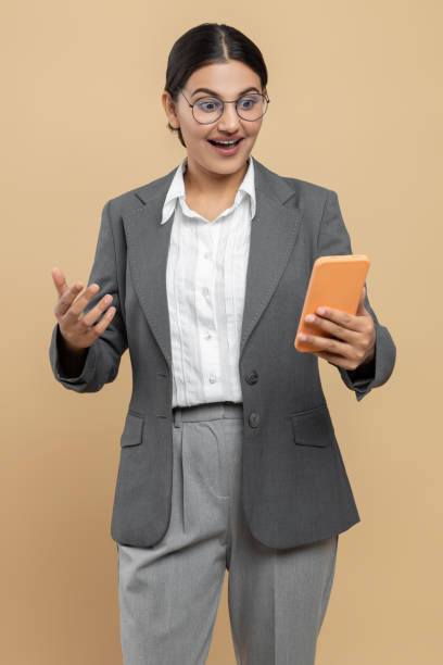 istock Shocked Indian woman in official style jacket using mobile phone checking e-mails or online job schedule 2154743402