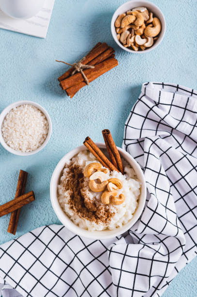 istock Bowl with delicious rice pudding with cinnamon and nuts on the table top and vertical view 2154744344