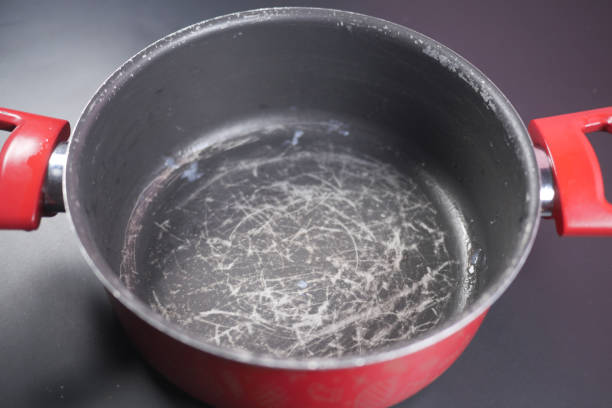 istock scratched frying pan on black background 2154751052