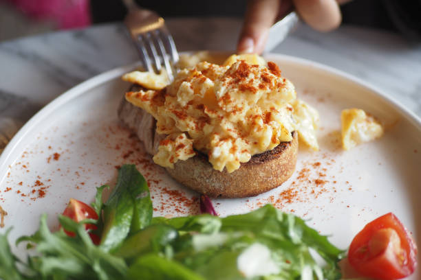istock morning breakfast with Scrambled eggs on a bread on white plate 2154751391