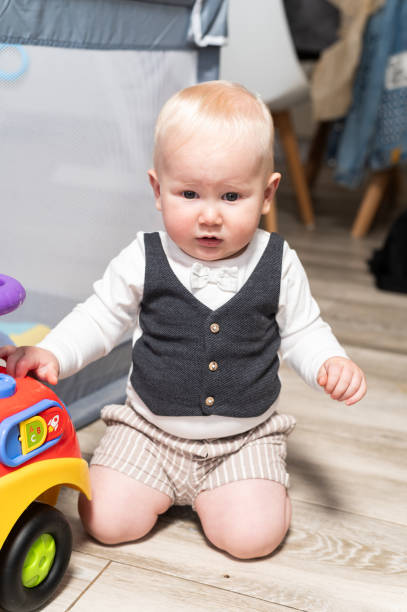 istock Baby boy with a toy kneeling indoors 2154754482