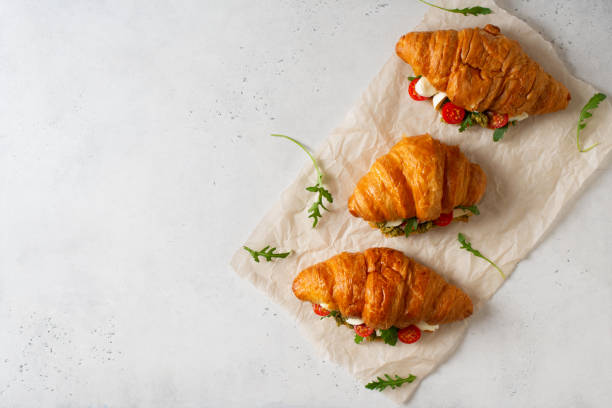 istock Few croissants with tomatoes, cheese and pesto with leaf arugula 2154755482