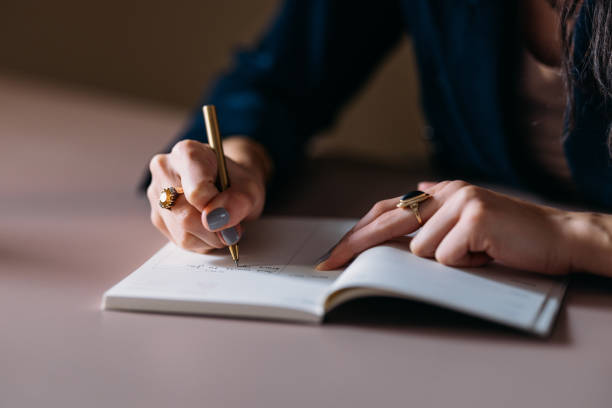 istock Woman Writing in Planner at Desk, Close-up View 2154762859