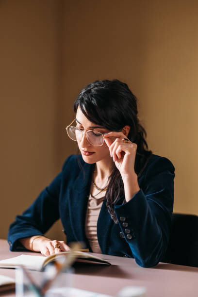 istock Focused Professional Woman Reviewing Documents at Desk 2154762900