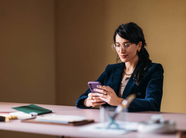 istock Professional Woman Using Smartphone at Her Office Desk 2154762901