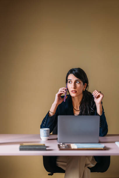 istock Professional Woman Talking on Phone at Her Desk 2154762921