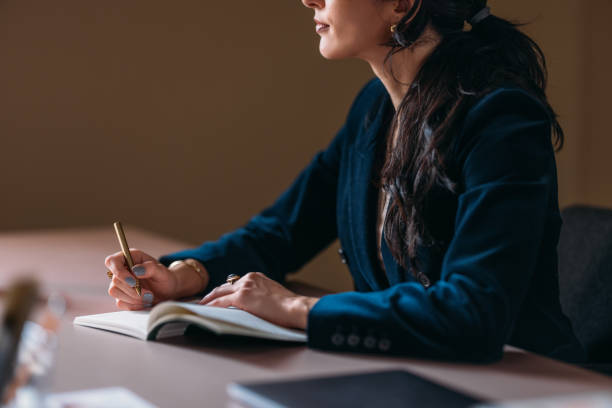 istock Businesswoman Writing Notes in a Stylish Notebook 2154762972