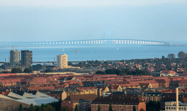 Aerial view of the Øresund Bridge connecting Denmark and Sweden on a partly sunny day with dramtic skies.