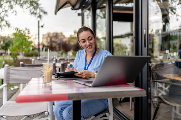istock Nurse pens notes in cafe garden 2154764392