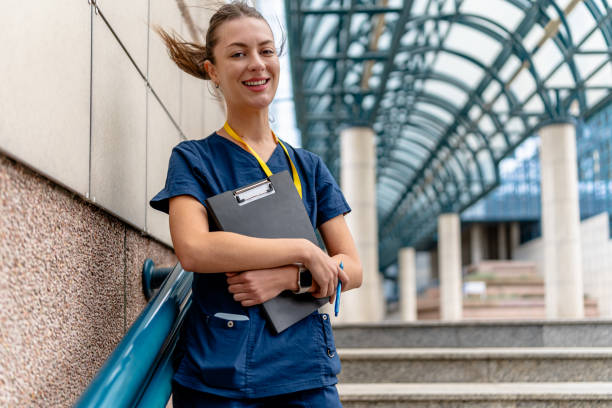 istock Nurse stands on outdoor staircase with clipboard 2154764805