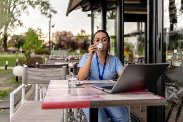 istock Young nurse enjoys coffee in cafe garden 2154765076
