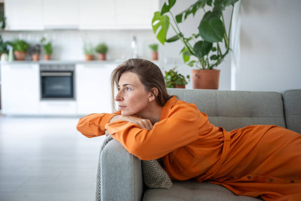 istock Thoughtful dreaming woman lying on sofa looking aside window enjoy calmness for tranquil relaxation. 2154766387